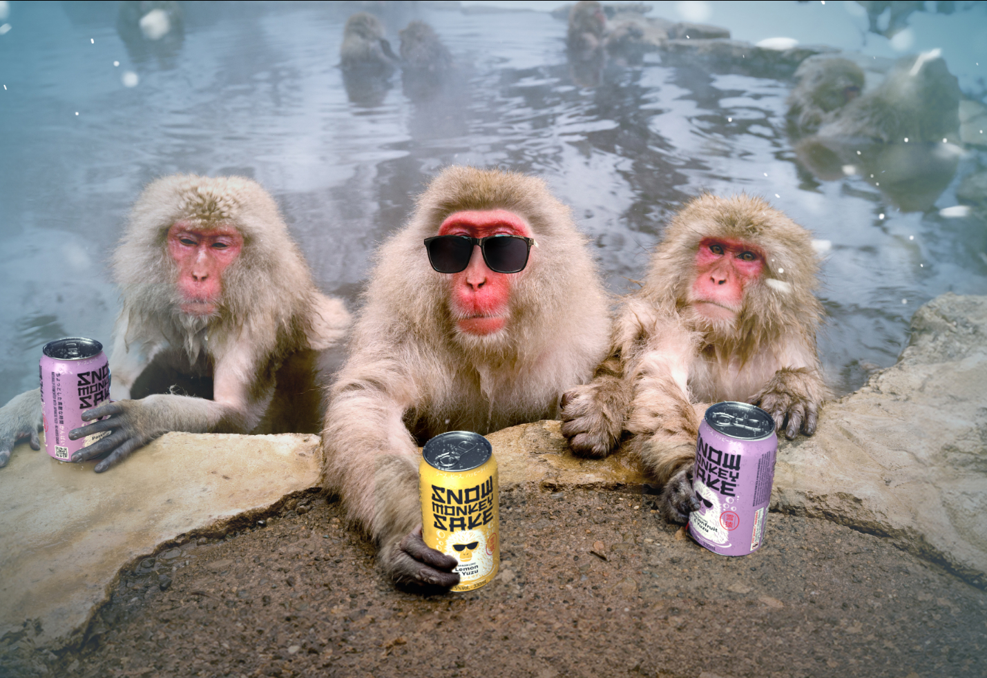 Three monkeys in a hot spring, each holding a can of Snow Monkey Sake